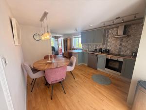 a kitchen with a wooden table and purple chairs at Peaceful Red Deer Cosy Apt in Letterfrack near The Connemara National Park in Letterfrack