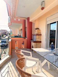 a kitchen with a glass table and chairs on a balcony at Keremidis Apartment in Flogita