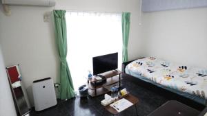 a bedroom with a bed and a television in it at Comfort CUBE PHOENIX MIYAZAKI in Miyazaki