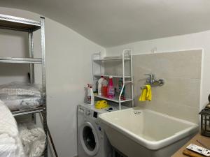 a laundry room with a sink and a washing machine at Affittacamere Point Concept Rooms in Laurito