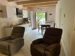a kitchen and dining room with two chairs and a table at Affittacamere Point Concept Rooms in Laurito