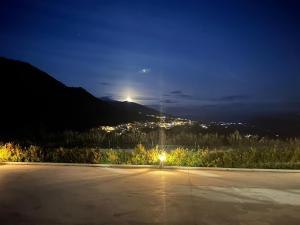 an empty parking lot at night with the moon at Affittacamere Point Concept Rooms in Laurito