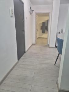 a hallway with white walls and tile floors at ArtStay Apartment in Drobeta-Turnu Severin