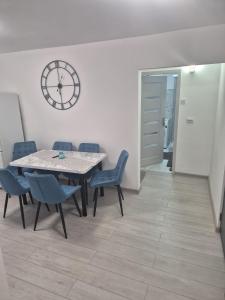 a dining room with a table and chairs and a clock at ArtStay Apartment in Drobeta-Turnu Severin