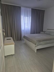 a bedroom with a bed and a window with curtains at ArtStay Apartment in Drobeta-Turnu Severin