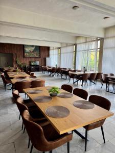 a large room with tables and chairs and windows at Хижа Оборище in Oborishte