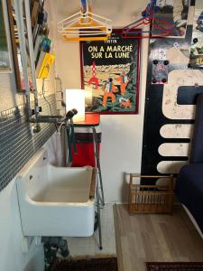 a bathroom with a sink and a poster on the wall at Genbrugsfabrikkens Tiny apartment in Holbæk