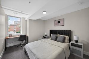 a bedroom with a bed and a desk and a window at Sleek 2BR apartment in prime location in Reading