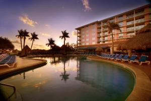 a hotel with a pool with chairs and palm trees at Palm Beach Shores Resort and Vacation Villas in Palm Beach Shores