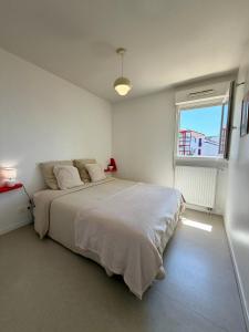 a bedroom with a large bed and a window at Pays Basque Ciboure - calme, port & plages à pied in Ciboure