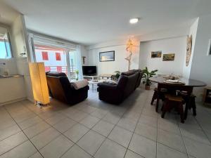 a living room with couches and a table and a tv at Pays Basque Ciboure - calme, port & plages à pied in Ciboure