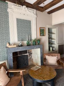 a living room with a fireplace and a table at Maison Romy in Chinon