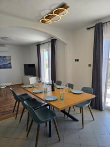 a dining room with a large wooden table and chairs at Villa Castelana in Barbat na Rabu