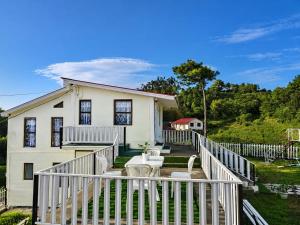 a white house with a white rail fence at Cozy corner Homestay in Mawphlang