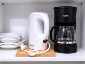 a black and white coffee maker sitting on a shelf at Milestone Terrace - Premium Apartment near Airport & Super U in Antananarivo