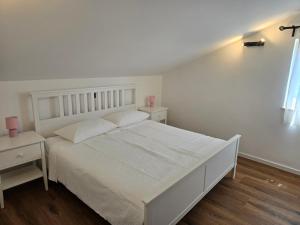 a white bedroom with a white bed and two tables at Villa Castelana in Barbat na Rabu +29 photos
