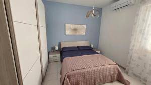 a small bedroom with a bed and blue walls at Viben House in Gallipoli