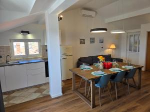 a kitchen and living room with a table and chairs at Villa Castelana in Barbat na Rabu