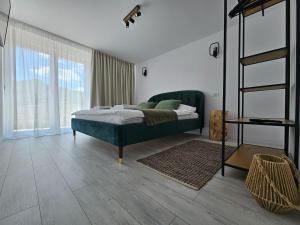 a bedroom with a bed and a large window at FurtuNest in Roşcoiu