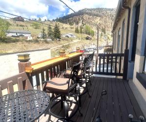 a deck with chairs and tables on a balcony at Aspen Inn in Creede