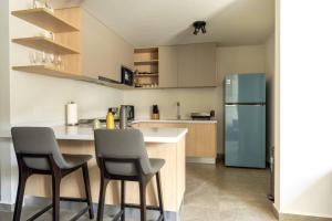 a kitchen with two chairs and a refrigerator at Un escape moderno dentro de Zibatá in San Vicente Ferrer +9 photos