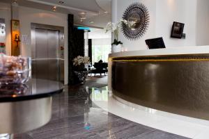 a lobby with a reception desk in a building at Clarion Collection Hotel Tapto in Stockholm