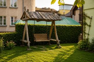 a gazebo with a bench in a yard at Adomo Rojus in Palanga