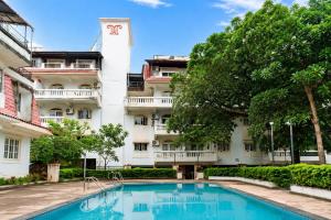a hotel with a swimming pool in front of a building at 400 m from thE beach 1bhk in Colva