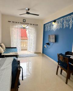 a living room with a blue wall and a table at 400 m from thE beach 1bhk in Colva +32 photos