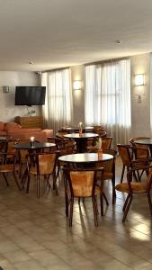 ein Esszimmer mit Tischen, Stühlen und einem Sofa in der Unterkunft Hotel Euromar in Rimini