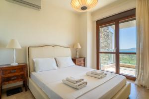 a bedroom with a bed with two towels on it at Villa Malvina in Neos Marmaras +54 photos