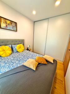 a bedroom with a bed with yellow pillows on it at Matas old town apartment in Kaunas