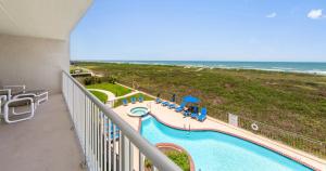 a view of a pool and the ocean from a balcony at Edgewater Condo Unit #304 in South Padre Island