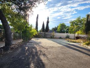an empty road with a white fence and trees at Guest house in Tujunga