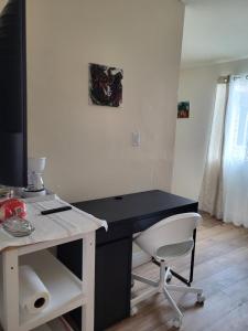 a black desk with a white chair in a room at Guest house in Tujunga