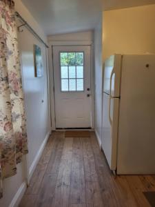 a hallway with a white door and a refrigerator at Guest house in Tujunga