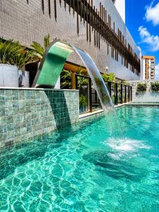 ein Springbrunnen in einem Schwimmbecken in einem Gebäude in der Unterkunft Std Design Mar in Maceió