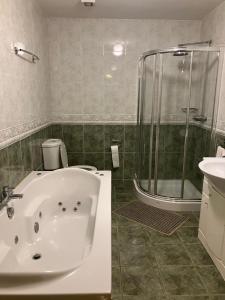 a bathroom with a tub and a shower and a sink at Clifden townhouse in Clifden +7 photos
