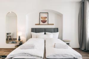 a bedroom with two white beds and a mirror at Residenz am Altmarkt in Löbau +23 photos