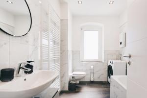 a white bathroom with a sink and a toilet at Residenz am Altmarkt in Löbau