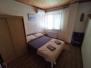 a bedroom with a bed with two towels on it at Guest House Dijana in Kraljevica