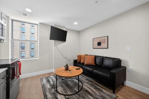 a living room with a black couch and a table at Elegant 2BR apartment with updated kitchen in Reading