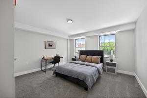 a bedroom with a bed and a desk and windows at Elegant 2BR apartment with updated kitchen in Reading