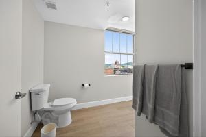 a white bathroom with a toilet and a window at Elegant 2BR apartment with updated kitchen in Reading +12 photos