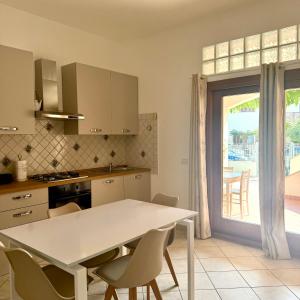 a kitchen with a table and chairs and a window at Luciana House in Olbia