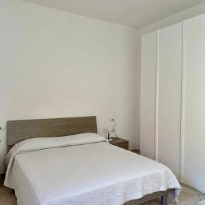 a white bedroom with a bed with a white blanket at Luciana House in Olbia