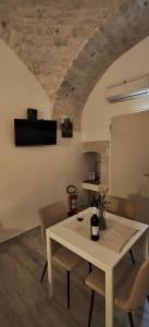 a dining room with a white table and chairs at Casa Italiannebrasille in Castellana Grotte