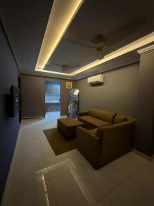 a living room with a couch and a television at Maison Eleve Residency in Lahore