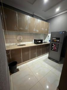 a small kitchen with a sink and a refrigerator at Maison Eleve Residency in Lahore