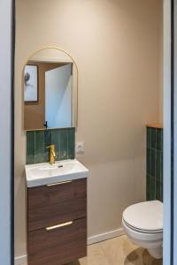 a bathroom with a sink and a toilet at Love Room avec Jacuzzi - Le cocon caché in Bressuire